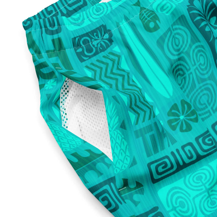 TIKI RETRO turquoise board shorts with geometric and floral patterns, revealing white texture